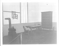 SA0423.6 - Photo of a table, chairs, cupboard, and stove. Identified on the back.
